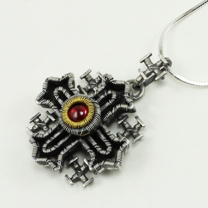 Angleshot of Jack Boglioli pendant Coptic cross with garnet and 24 k gold