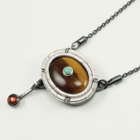 Angle shot of Tiger's Eye with Turquoise and Garnet Pendant by Jack Boglioli