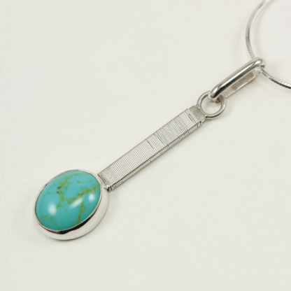Angle shot of Jack Boglioli bound bar pendant with turquoise