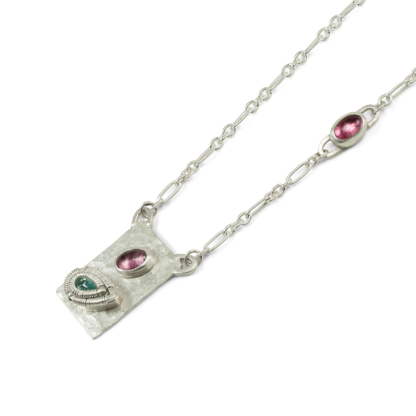 Angle shot of Jack Boglioli apatite pendant with pink tourmaline